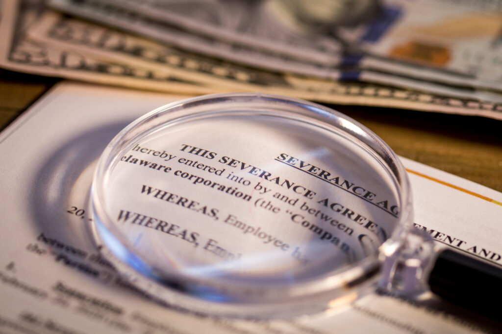Close up of magnifying glass over a severance agreement